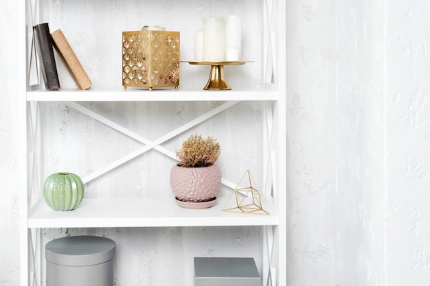 Wooden shelving unit with decor near grey wall.