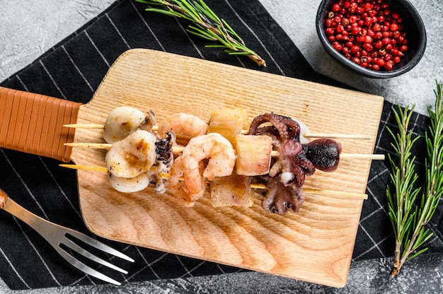 Wooden skewers with grilled seafood, shrimp, octopus, squid and mussels