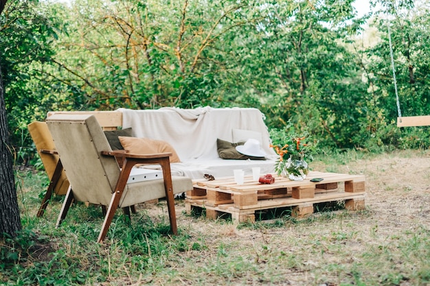 Wooden sofa with armchair and table on the backyard outdoors. Nobody