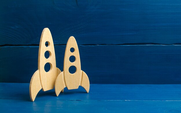 Photo wooden space rocket on a blue background. the concept of minimalism, high technologies