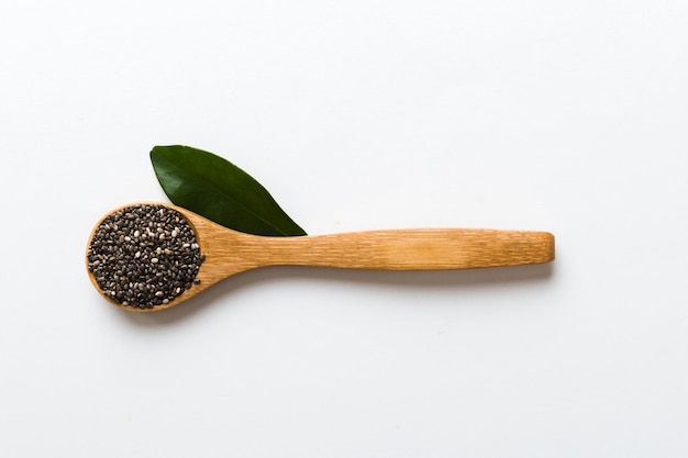 Wooden spoon and chia seeds on colored background top view Healthy Salvia hispanica Healthy superfood