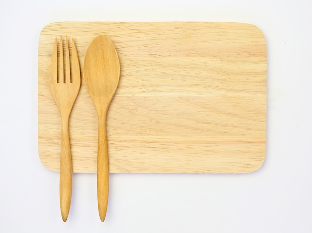 Wooden spoon and fork on wood board block isolated on white .