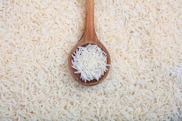 Wooden spoon on jasmine rice background