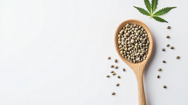 Photo wooden spoon with hemp seeds and leaf on white background