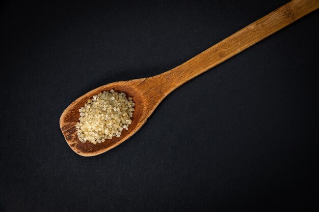 wooden spoon with salt and spices on a dark background