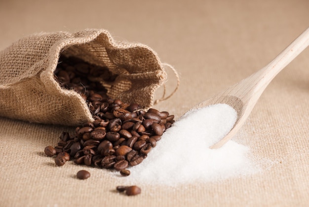 wooden spoon with sugar and raffia sack with coffee