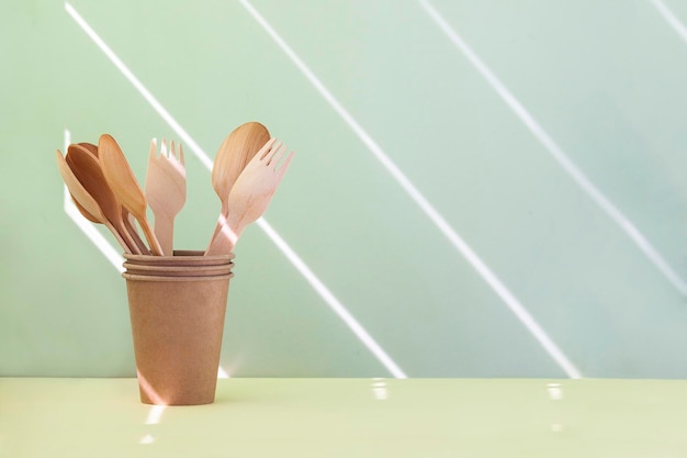 Wooden spoons and forks in paper glass Copy space zero waste concept