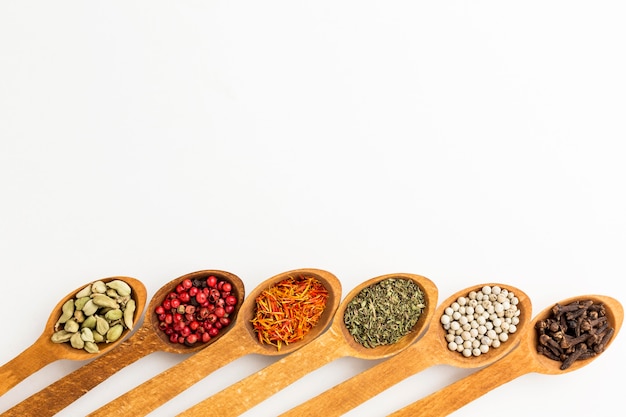 Wooden spoons with variety of spices with copy-space