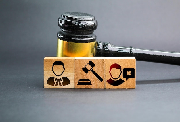 wooden square with three icons of the offender the judge and the lawyer the concept of judicial