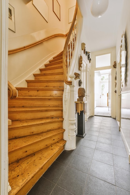 Wooden staircase in spacious hall of apartment