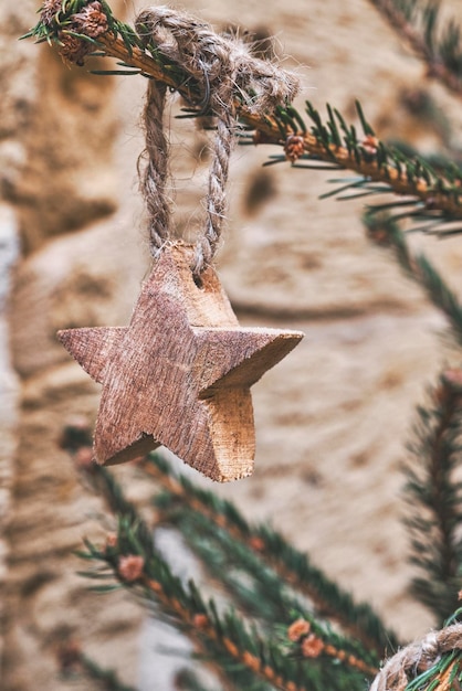 Wooden star on Christmas tree branch Handmade Christmas zerowaste ornaments