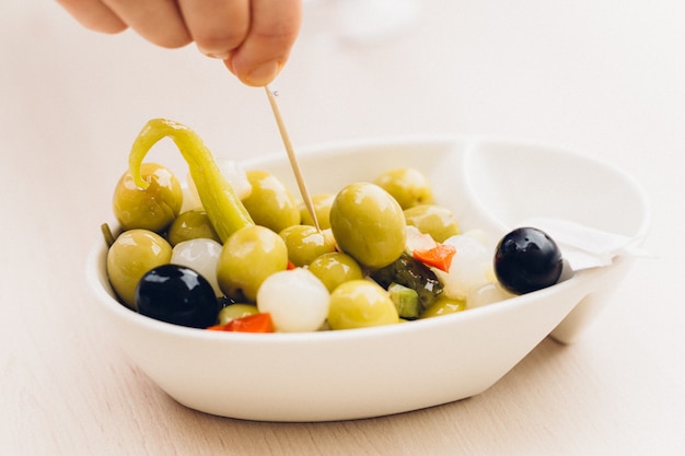 Wooden stick prodding vegetarian or vegan snac made up of olives, chilli, chives, and pepper. healthy snac concept. Mediterranean diet. Spain