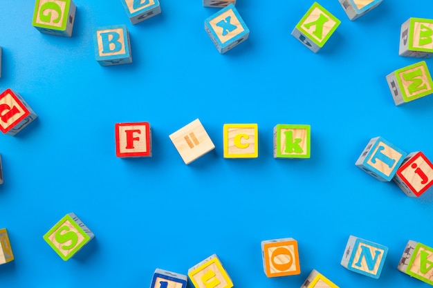 wooden surface colorful alphabet blocks on blue, flat lay, top view 