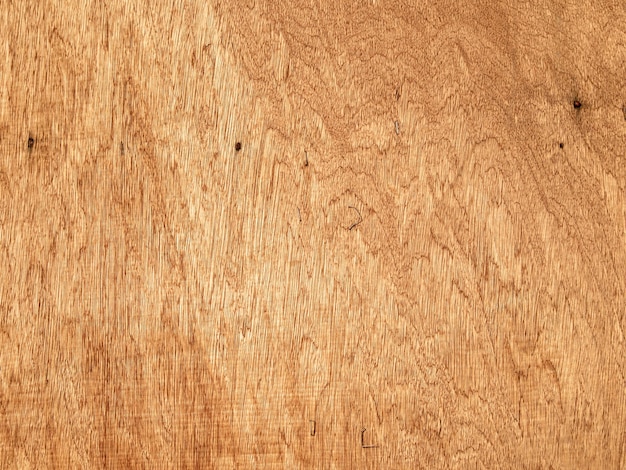 A wooden surface with a rough surface and the word wood. Abstract background, natural wood pattern.