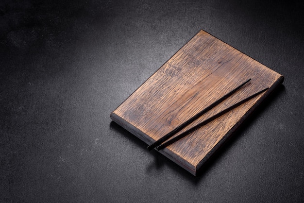 Wooden sushi sticks on a dark concrete background