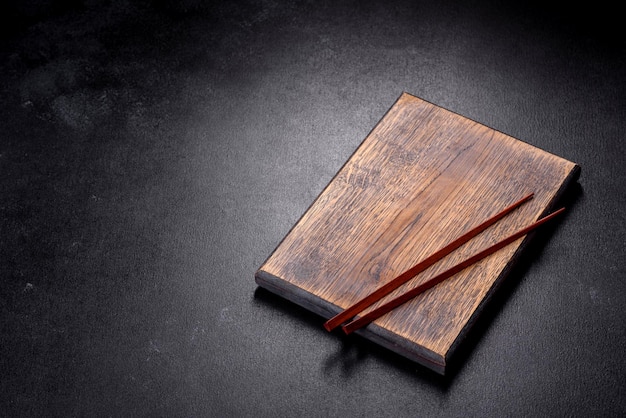 Wooden sushi sticks on a dark concrete background