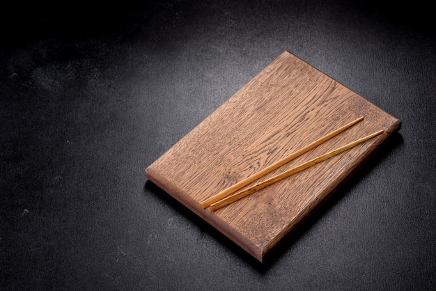 Wooden sushi sticks on a dark concrete background