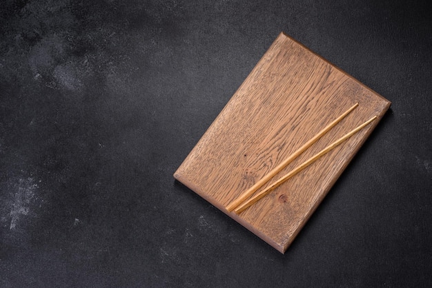 Wooden sushi sticks on a dark concrete background