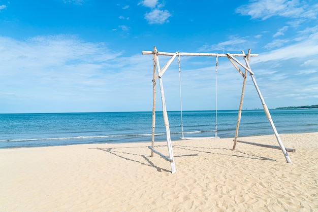 wooden swing on the beach with sea beach background