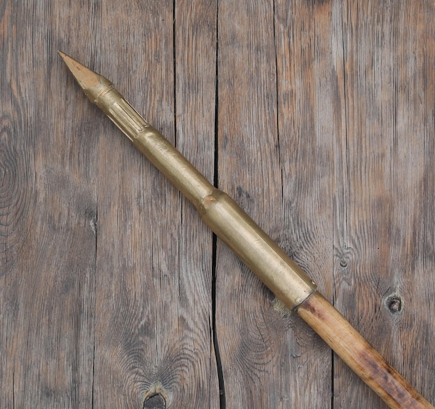 A wooden sword with a wooden handle is on a wooden table.