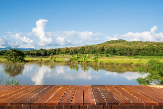 Wooden table background with a river view to place your products with various creative ideas