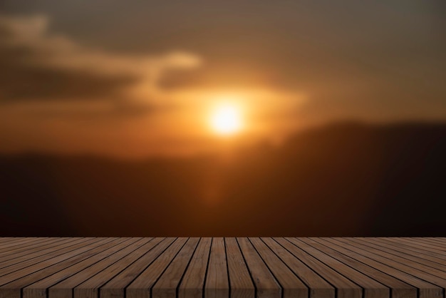 Wooden table and blur of beauty sunset sky and mountains as background