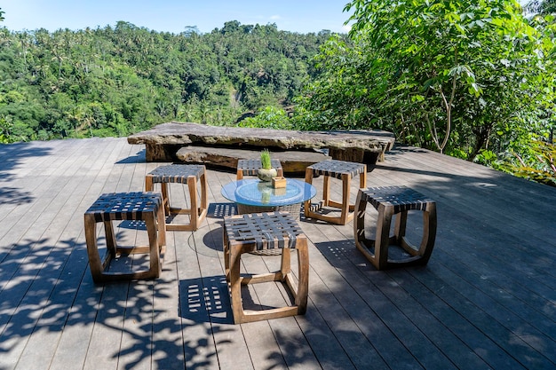 Wooden table and chairs in empty tropical cafe next to rice terraces in island Bali Indonesia