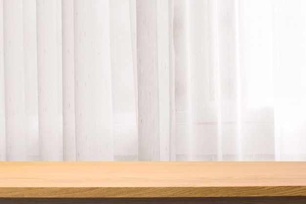 Wooden table on defocus window with curtain background