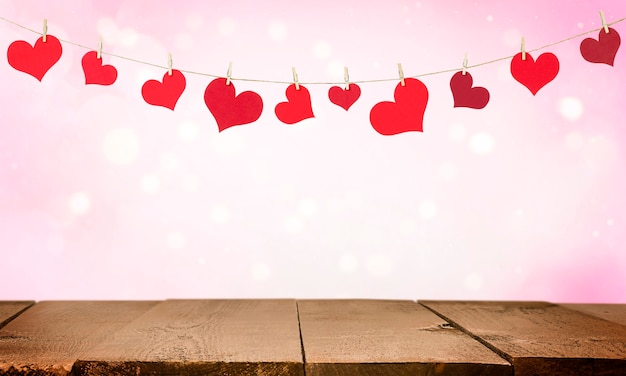 Wooden table and garland of valentines in the shape of hearts. wall for valentine's day.