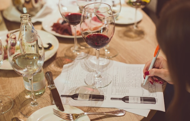 On a wooden table among glasses of wine and plates 