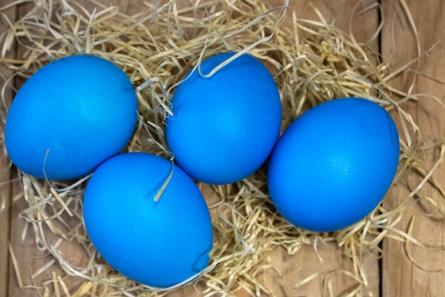 On a wooden table stained Easter eggs in a straw nest Easter and religion concept