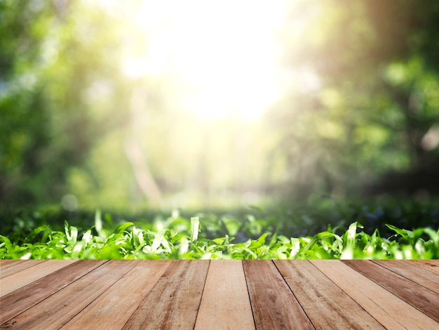 Wooden table top over green grass in summer garden.