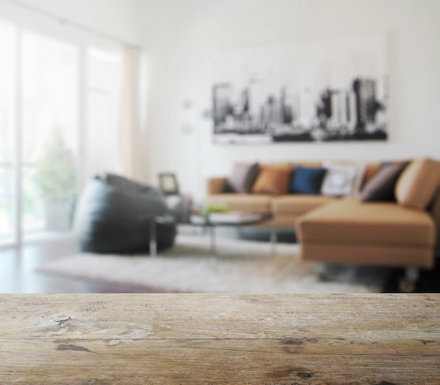 Wooden table top with blur of modern living room interior as background