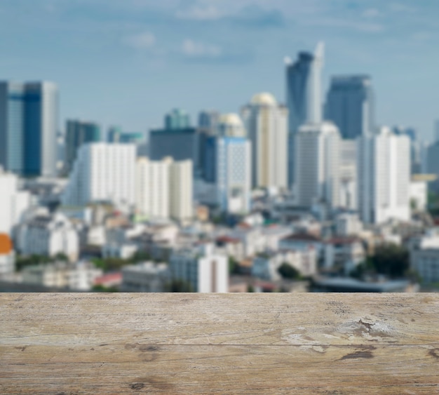 Wooden table top with blurred abstract background of bangkok downtown cityscape