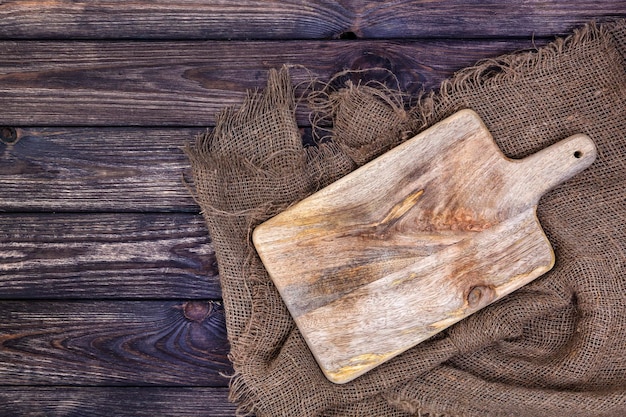 Wooden table with burlap cloth and cutting board