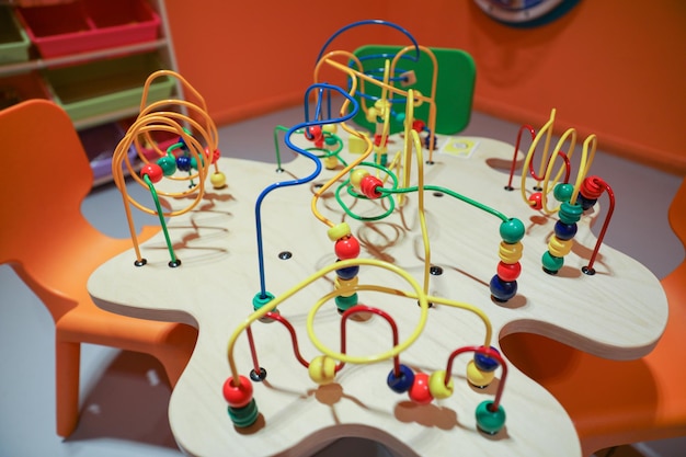 A wooden table with colorful beads and a wooden structure that says'play'on it