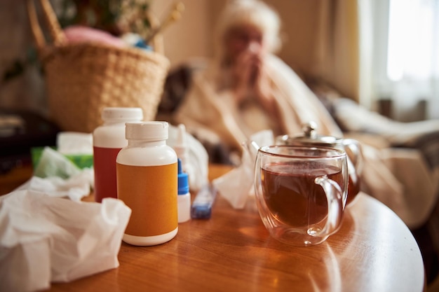 Wooden table with cup of tea and medicaments