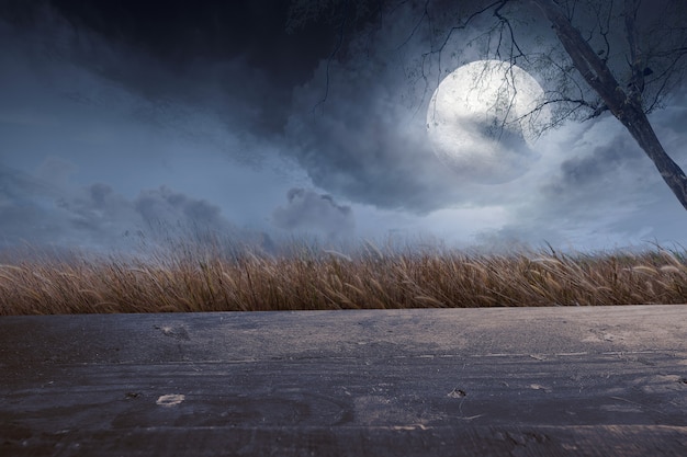 Wooden table with a full moon with dark cloudscapes on the night. Halloween concept