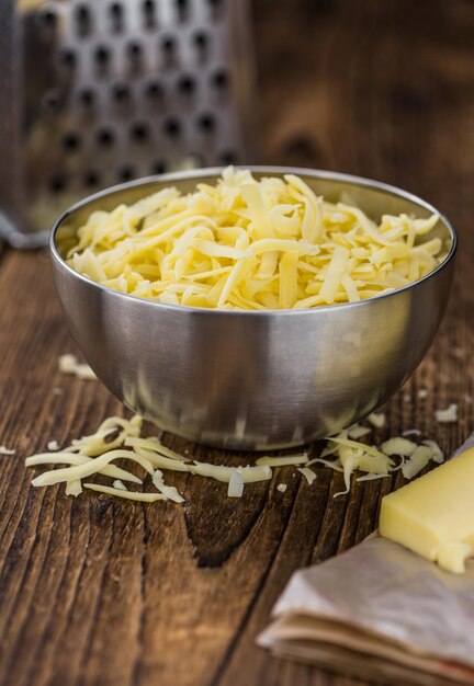 Wooden table with grated Cheese closeup shot