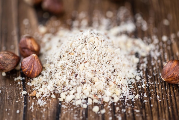 Wooden table with grounded Hazelnuts