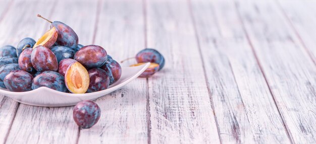 Wooden table with Plums selective focus