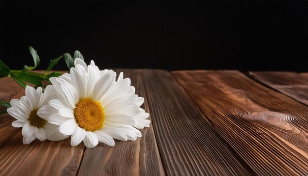 a wooden table with two daisies on it