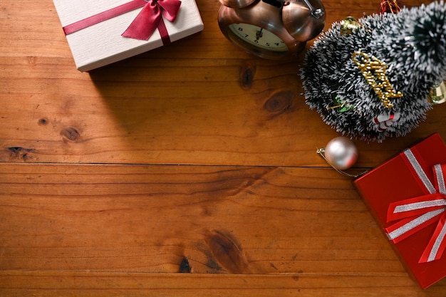 Wooden tabletop with gift boxes small Christmas tree vintage alarm clock and copy space