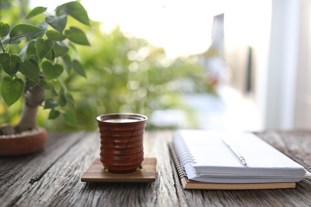 Wooden tea cup and notebooks with bodhi tree