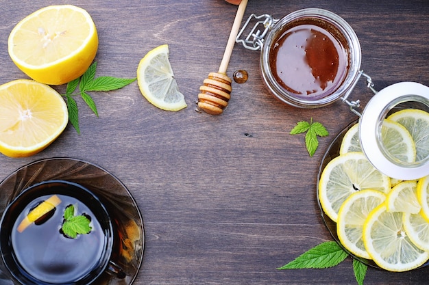 On a wooden texture background a lemon and honey on a spoon