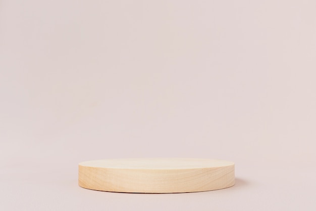 Wooden textured round low podium on a light background.