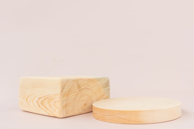 Wooden textured square and round podiums on a light background.