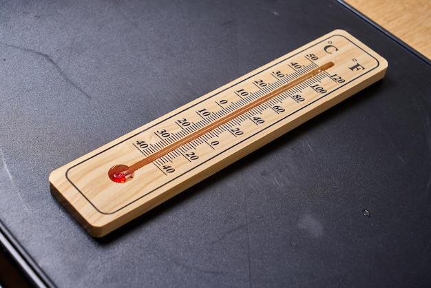 Photo a wooden thermometer with the letter c on it