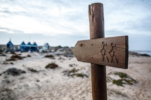 Wooden tourist pointer travelers with backpacks on a plate