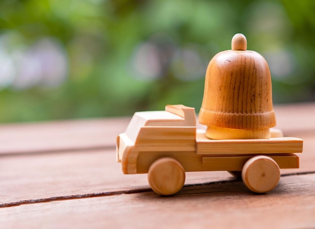 A wooden toy car with a bell on the front.